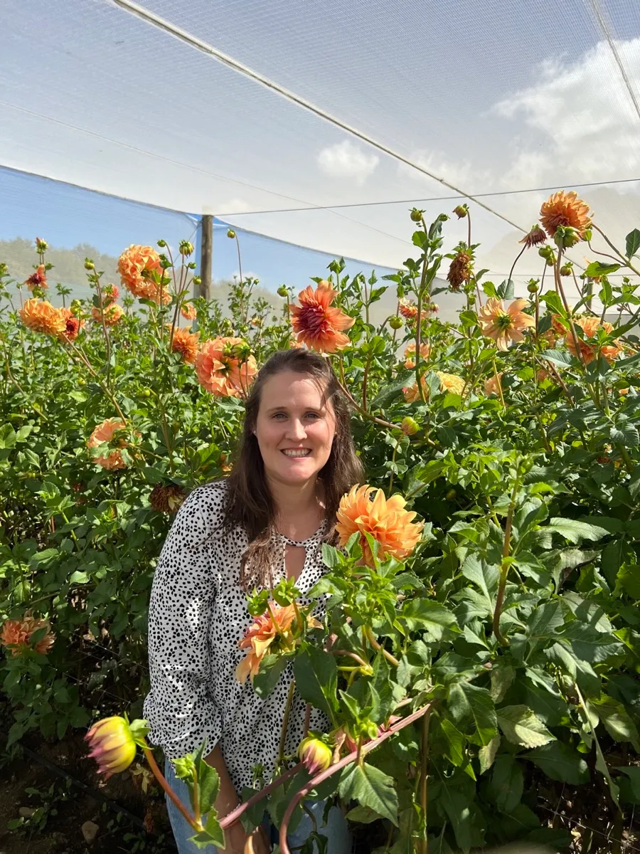 Brittany smiling among orange dahlias